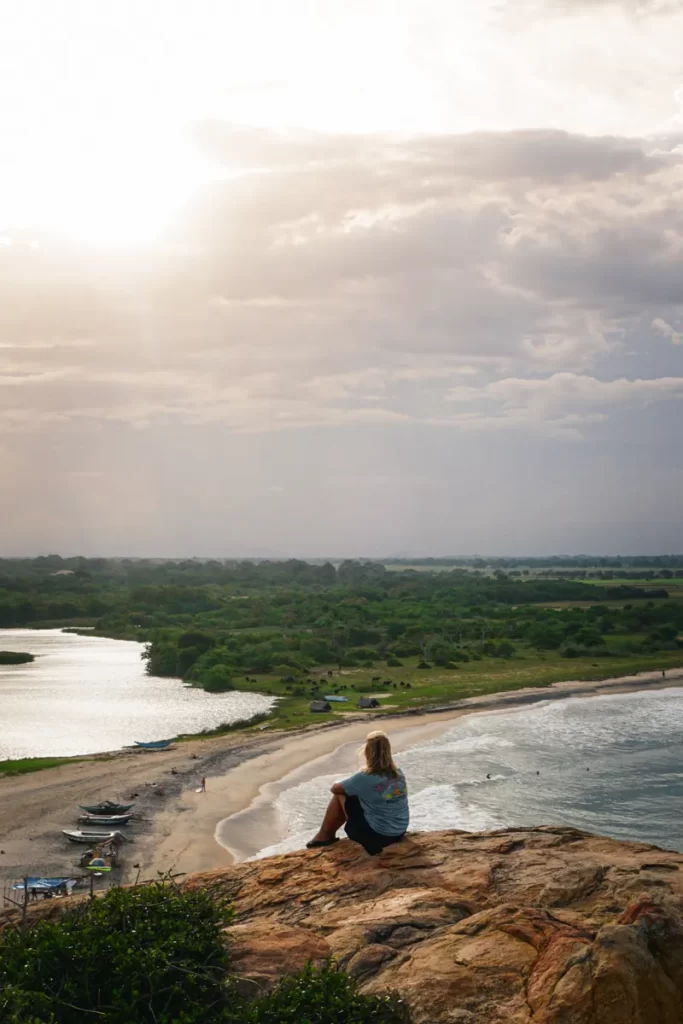 A girl sits on the top of Elephant Rock looking at the beach
