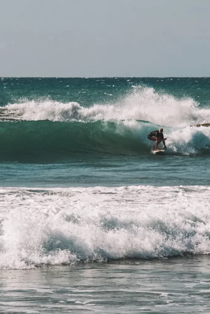 Surfer on a wave at lighthouse point near arugam bay