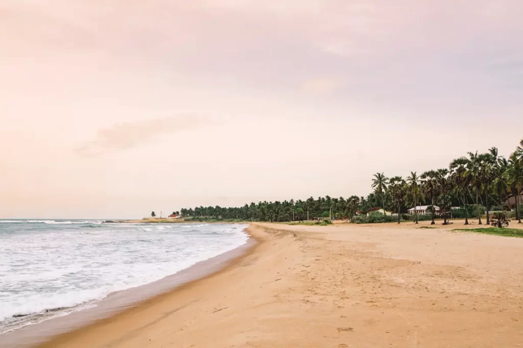 A beautiful pink sky at sunset on an empty beach near Arugam Bay