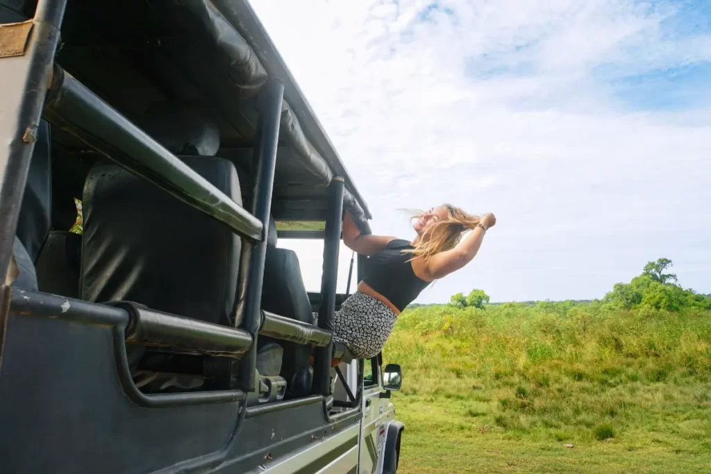 A girl leaning out of a jeep in Kumana National Park