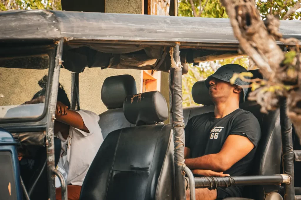Two people sleeping in a jeep at Kumana National Park