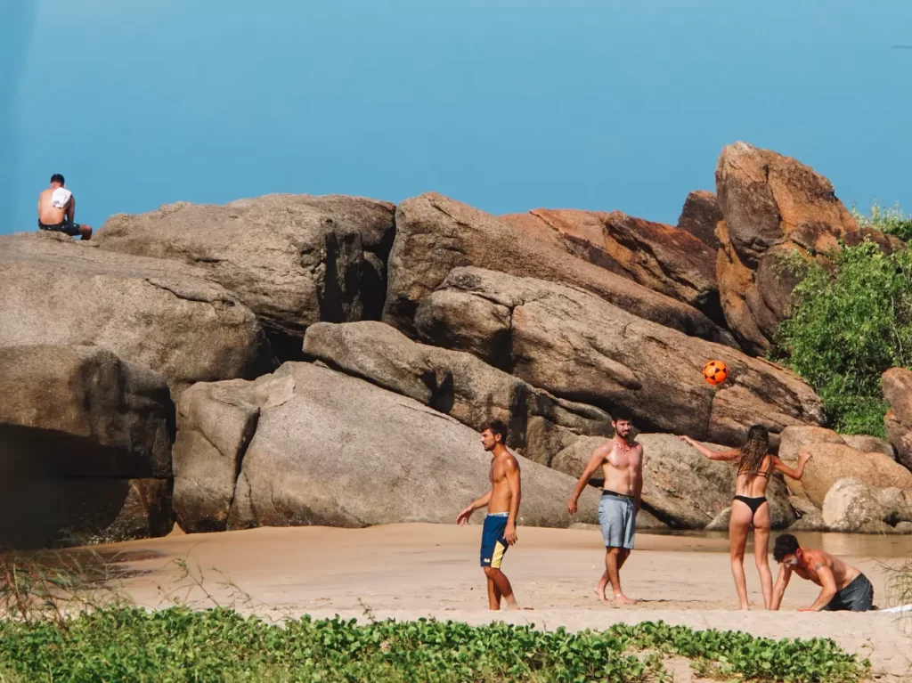 Travellers play with a ball on Peanut Farm Beach