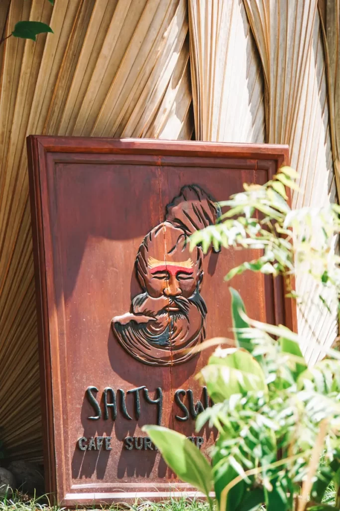 A carved wooden sign for Salty Swamis