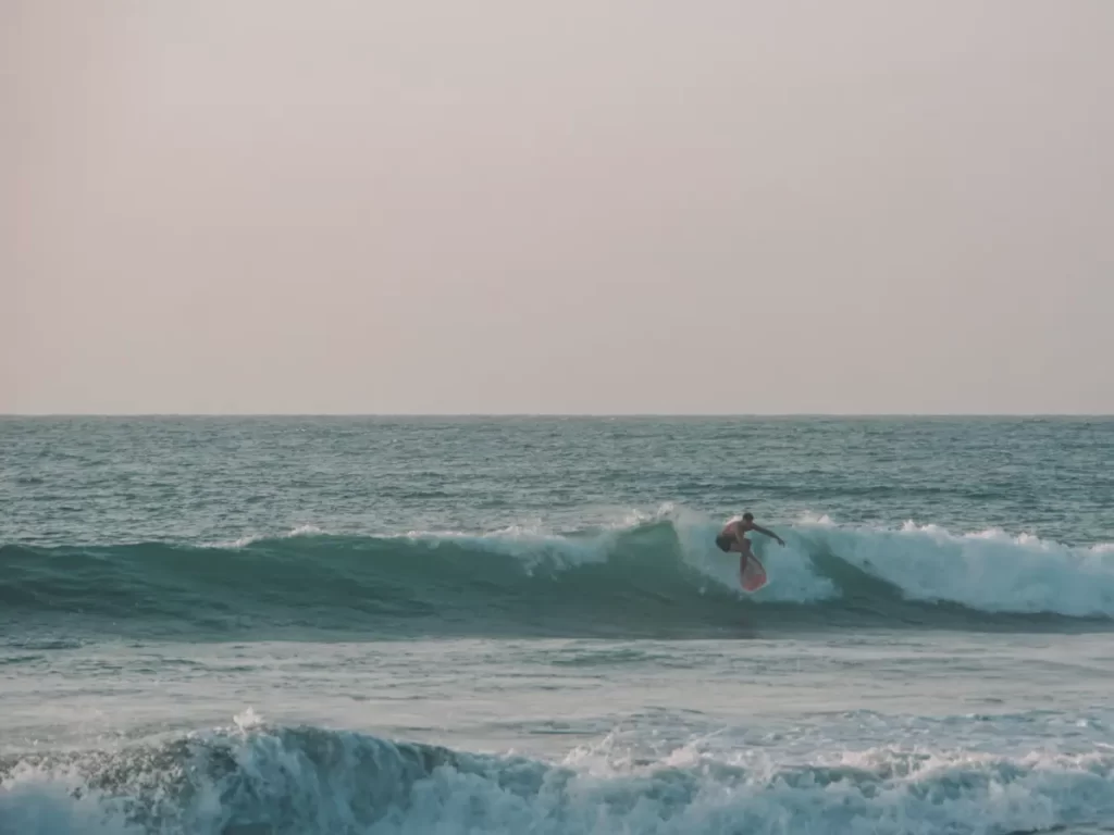 A surfer on a backside drop in at Lighthouse Arugam Bay