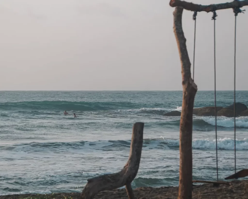 A big wave rolling into Lighthouse surf spot whilst only two people sit in the lineup