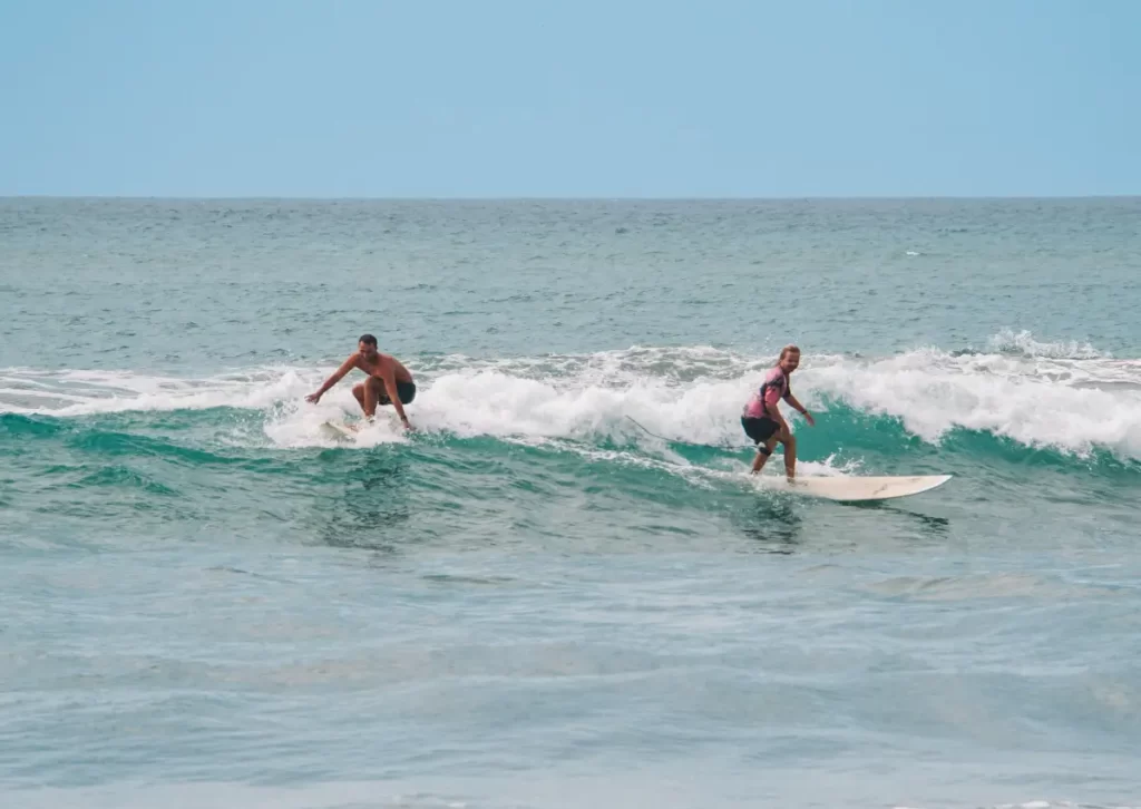 Two surfers attempting a crossover at Lighthouse surf spot near Arugam Bay