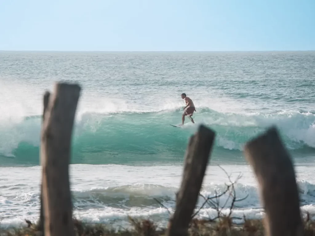 A surfer taking a high line on a wave at Lighthouse Arugam Bay