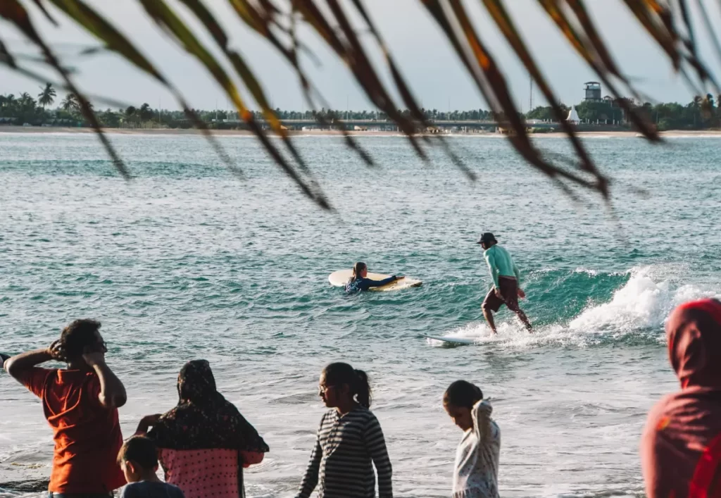 A crowd watches the surfers at Baby Point in Arugam Bay