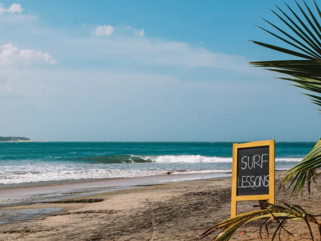 A sign saying surfboard lessons near Baby Point in Arugam Bay