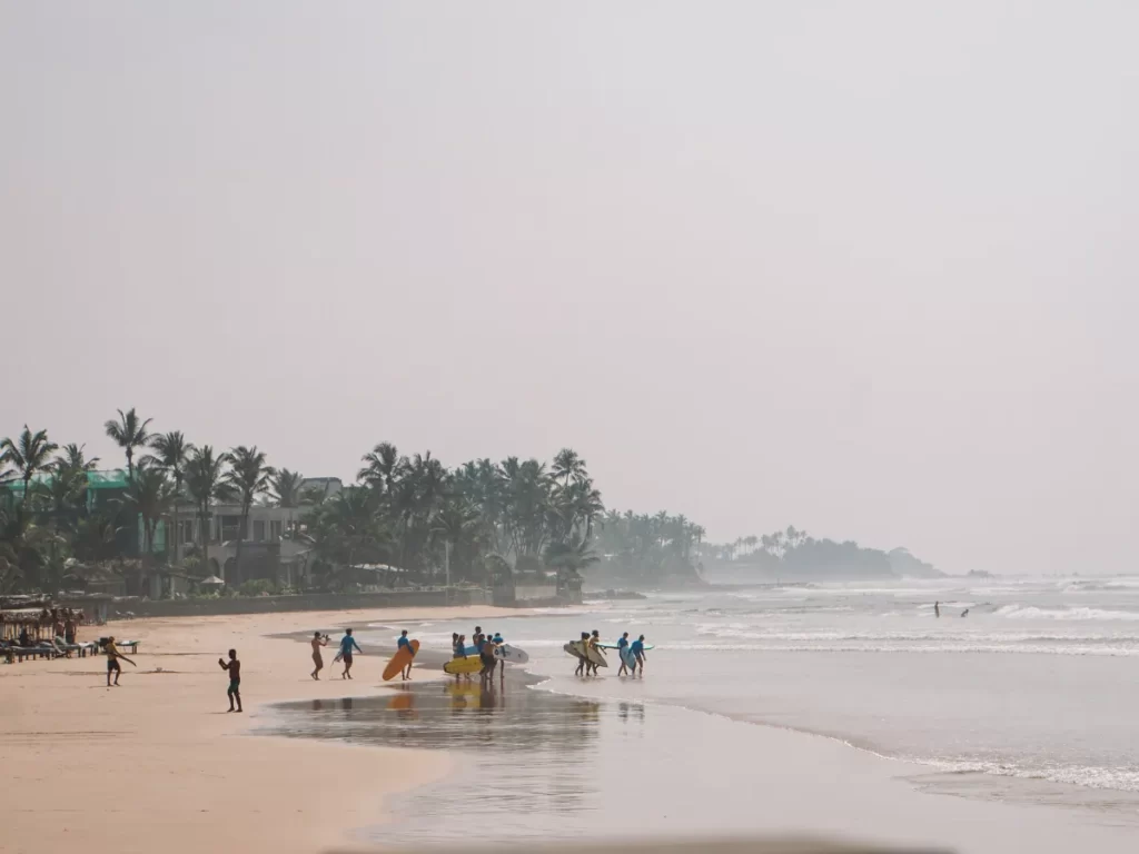A number of people playing on Kabalana beach at dusk