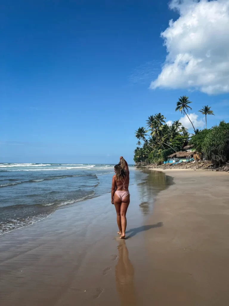 A girl in a bikini walking down kabalana beach