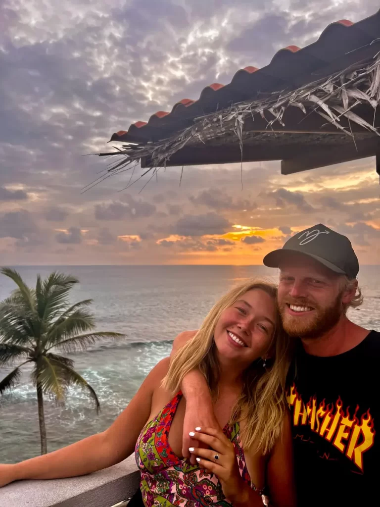 A couple hug on Lighthouse rooftop at sunset