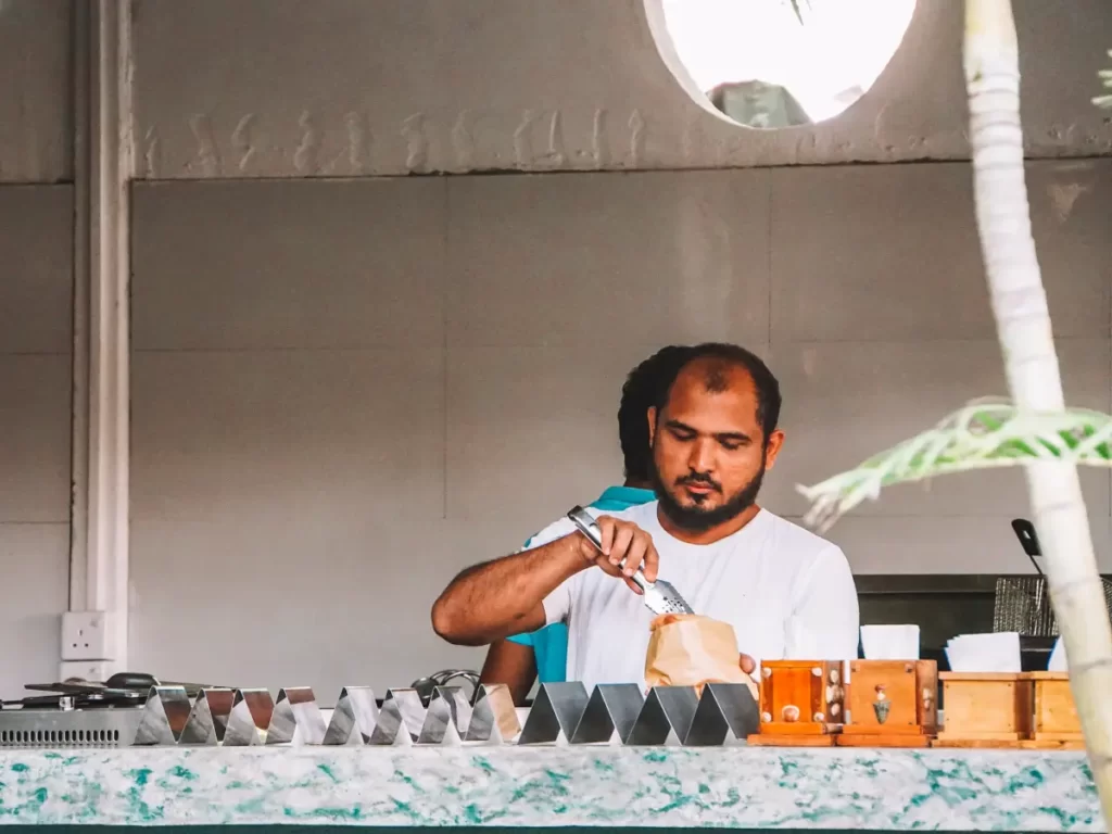 A man prepares a falafel pita at East Falafel, one of the best restaurants in Arugam Bay