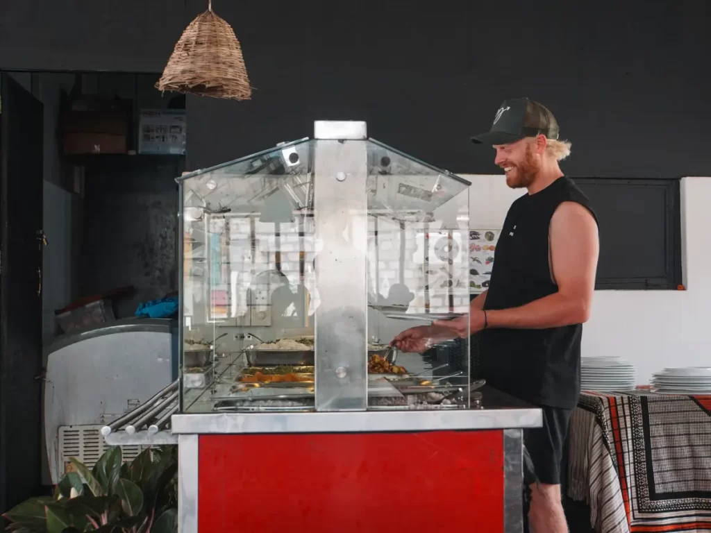 A man at Mama's rice and curry buffet filling his plate