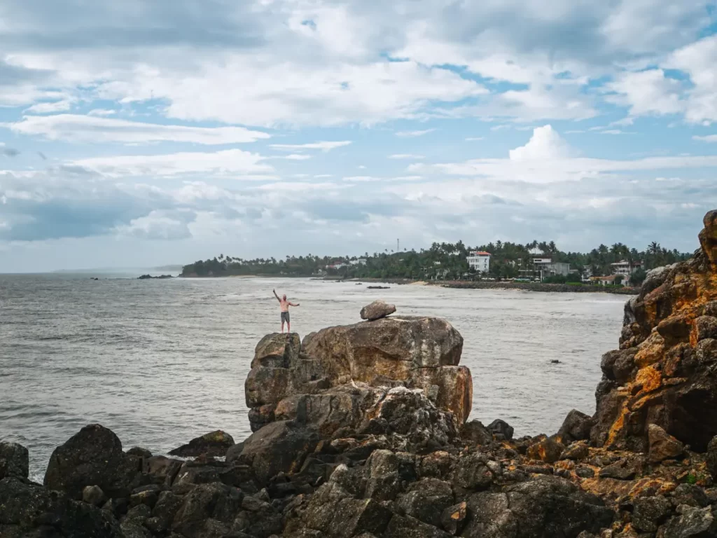 A man standing on top of Devils Rock in Ahangama