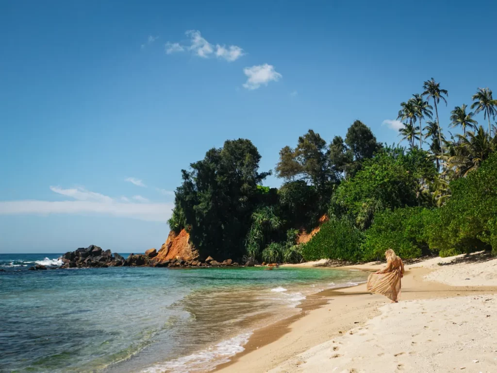 A girl walks down Secret Beach in Ahangama