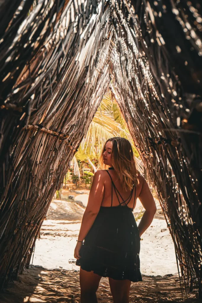 A girl walks though the palm shades at Hilltop Cabanas