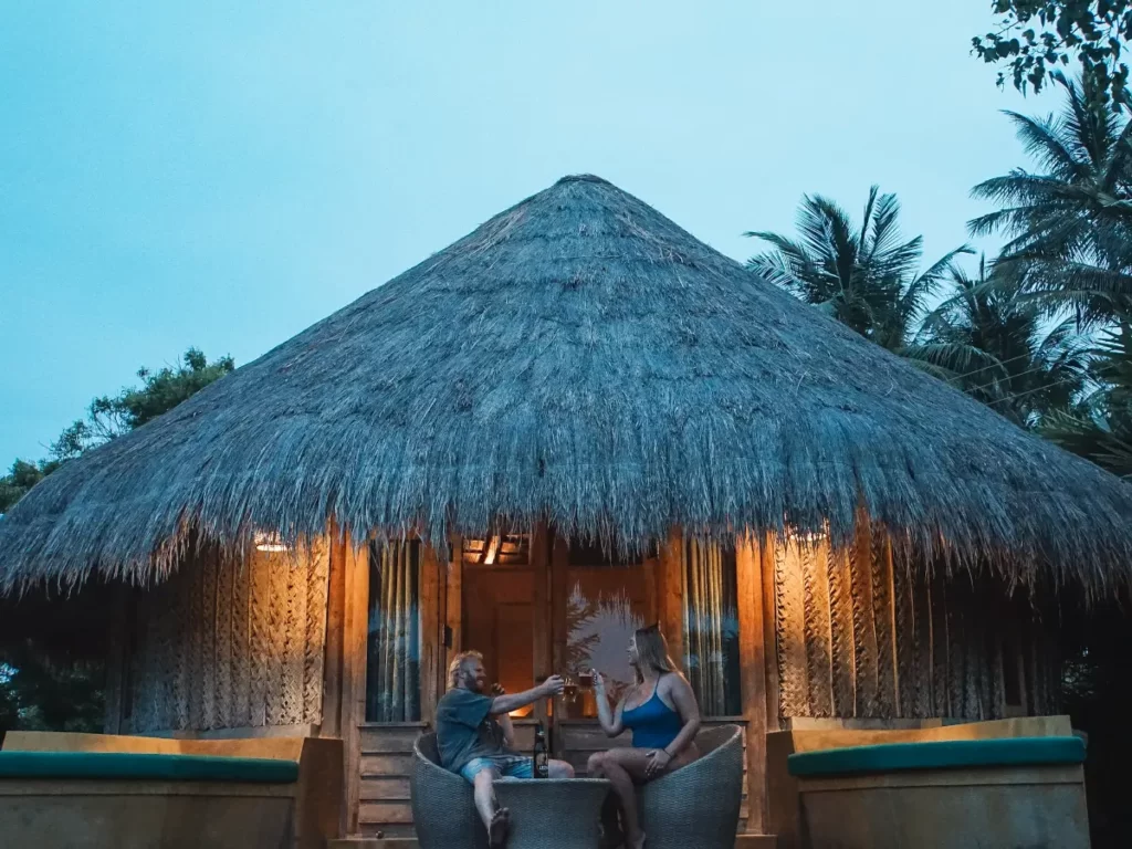 A couple drinks cocktails outside of their cabana at Jetwing Surf