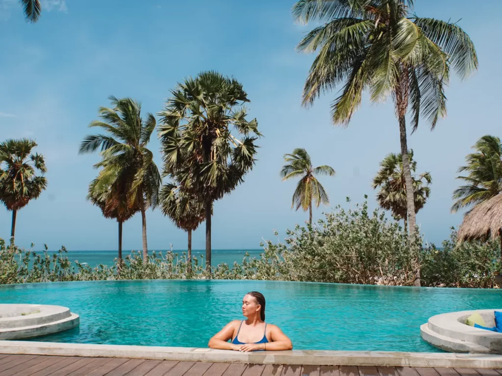 A girl is in the infinite pool at Jetwing Surf enjoying the sunshine