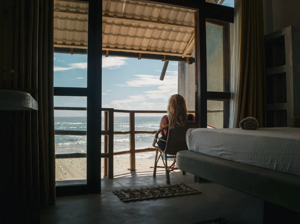 A girl sitting on the balcony at the marshmellow hotel and rooms