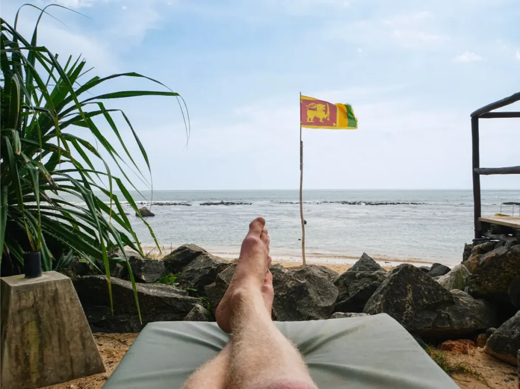 A man sitting on a sun lounger at Guni Beach Club in Madiha