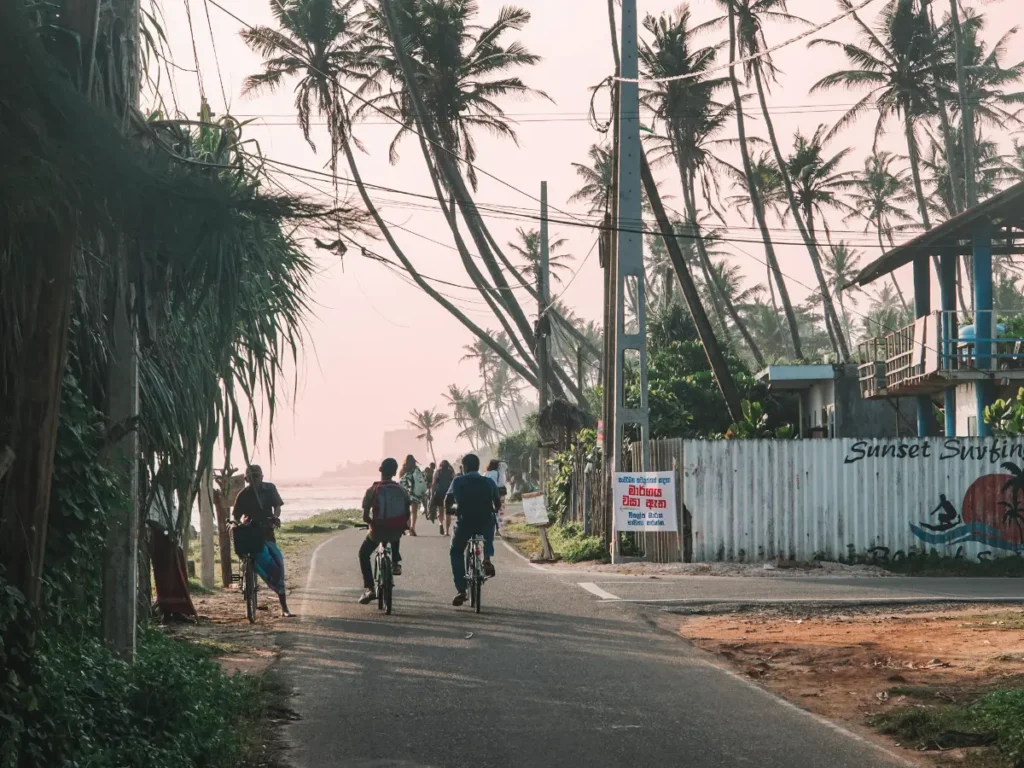 Two local cycling their bike down the main road in Madiha