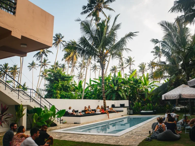 Groups of travellers hang around the pool in Spindrift Hostel