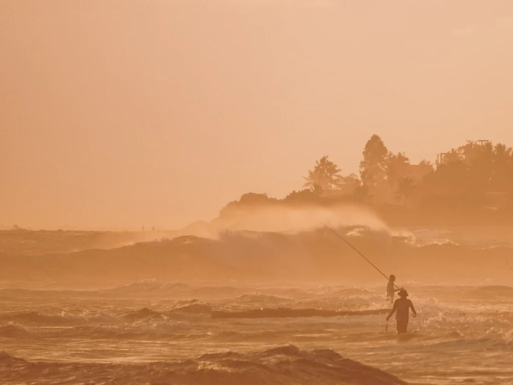 Two silhouettes of local fishermen in Madiha at sunset 