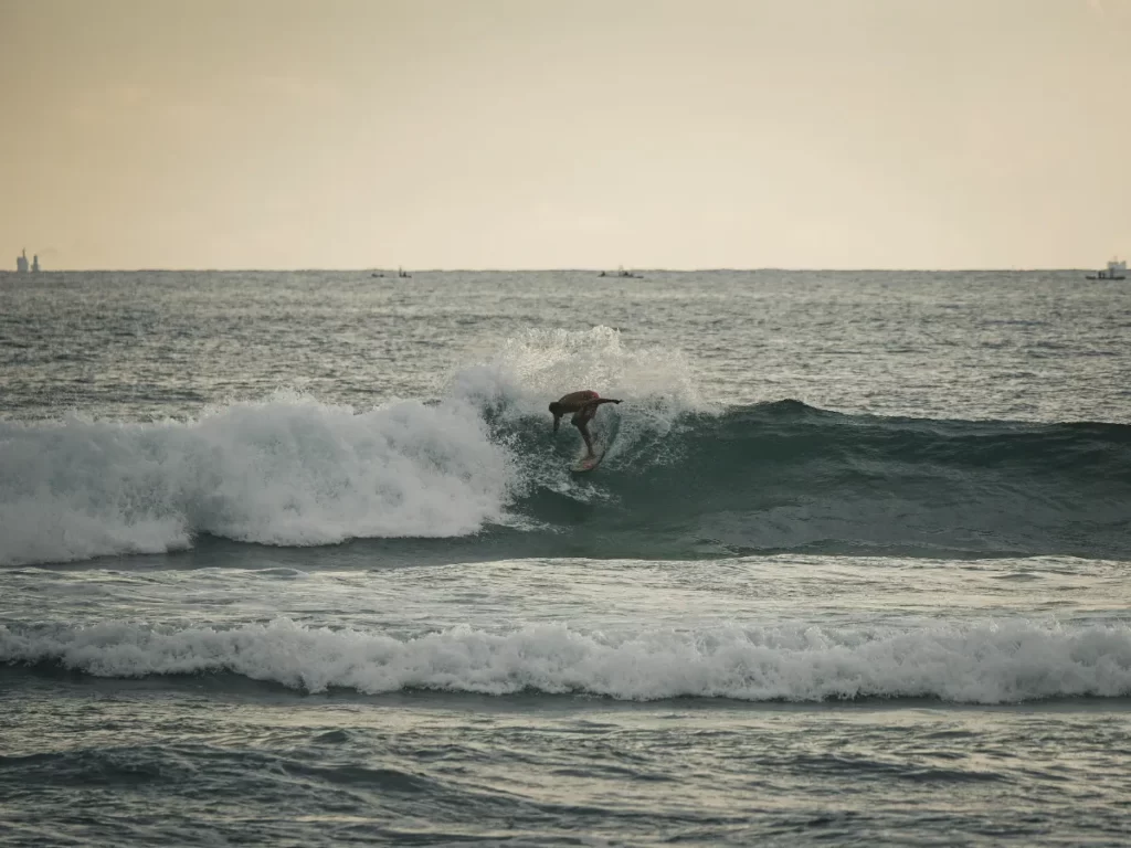 A surfer performs a cutback at The Rock Kabalana