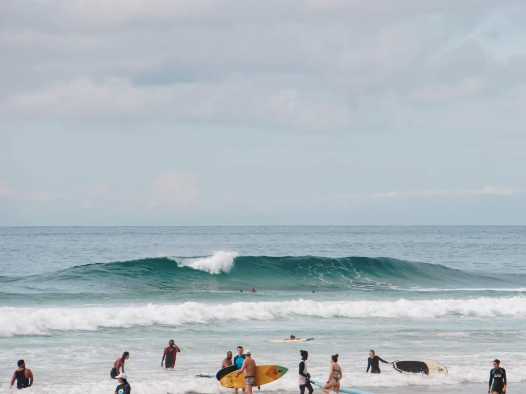 The wave at The Rock Kabalana with surfers walking past