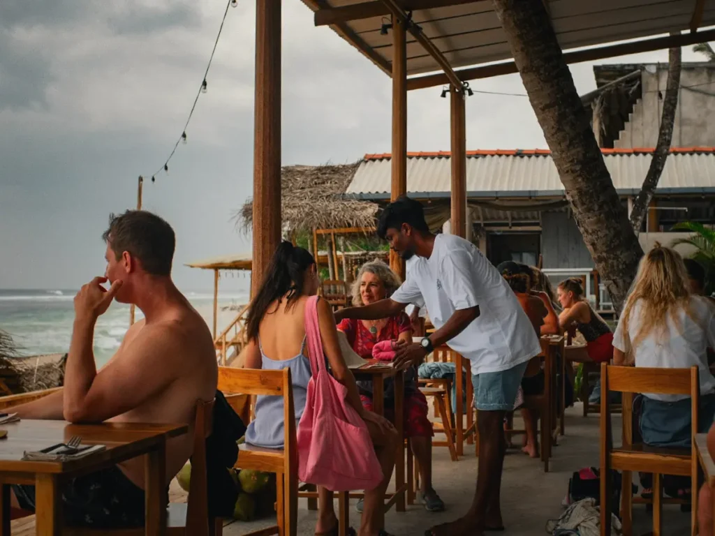 A man serves two laddies food at Ceylon Sliders in Ahangama