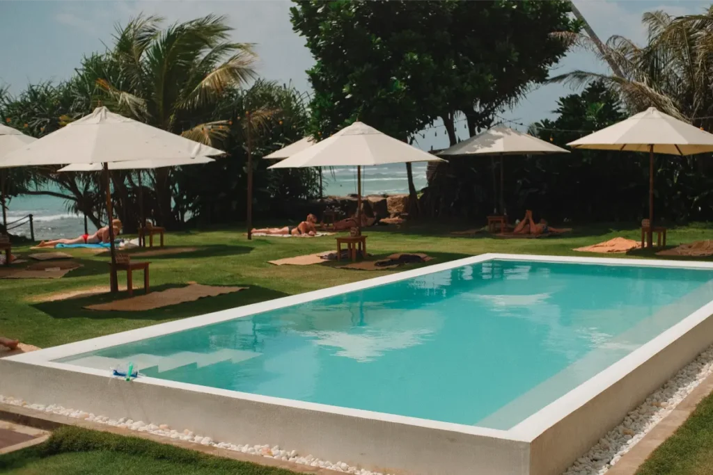 The pool and garden with parasols at Dreamsea Surf Camp 