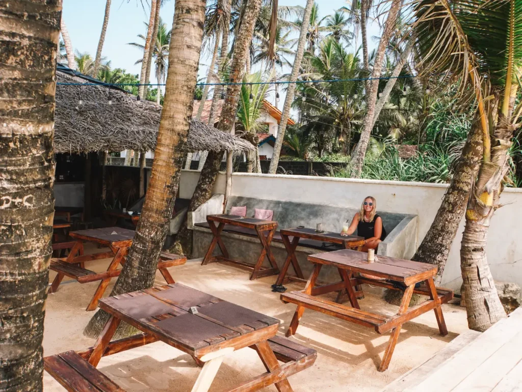 A girl sitting in the beachfront garden of Hakuna Matata