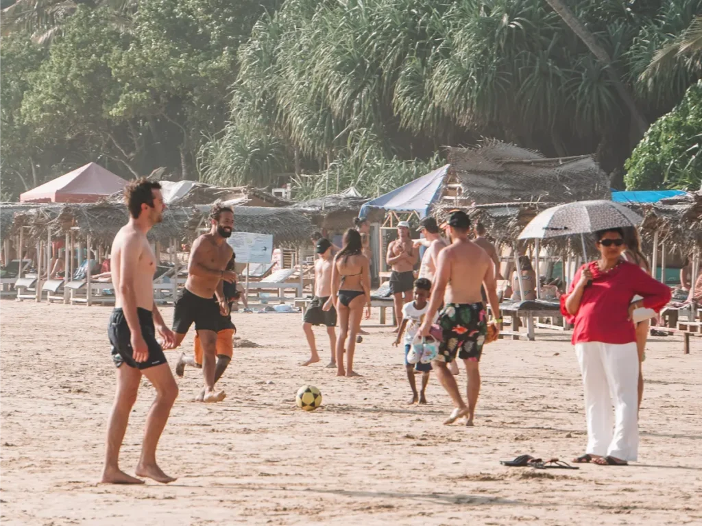 Tourist playing football with the local kids on Kabalana Beach