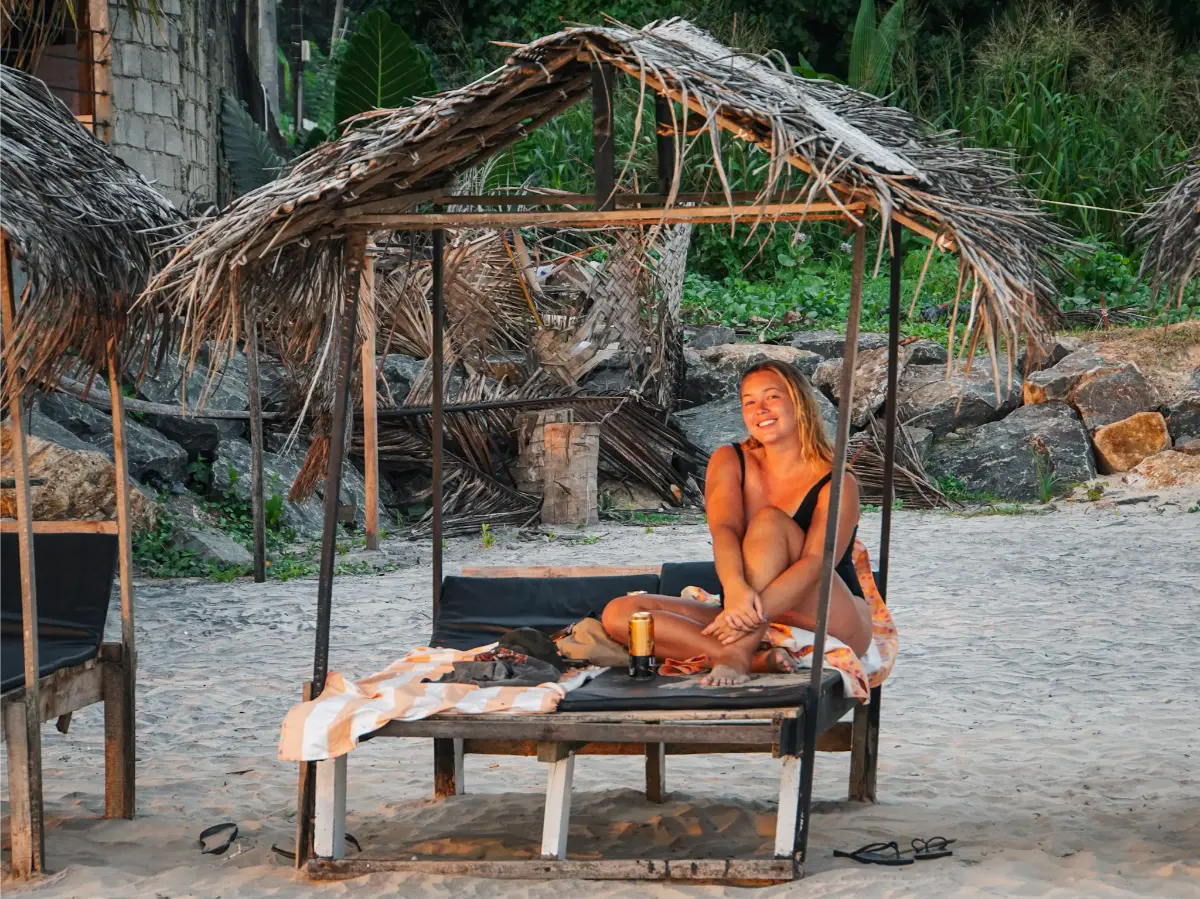 A girl smiles on one of the makeshift sun-beds at Kabalana beach