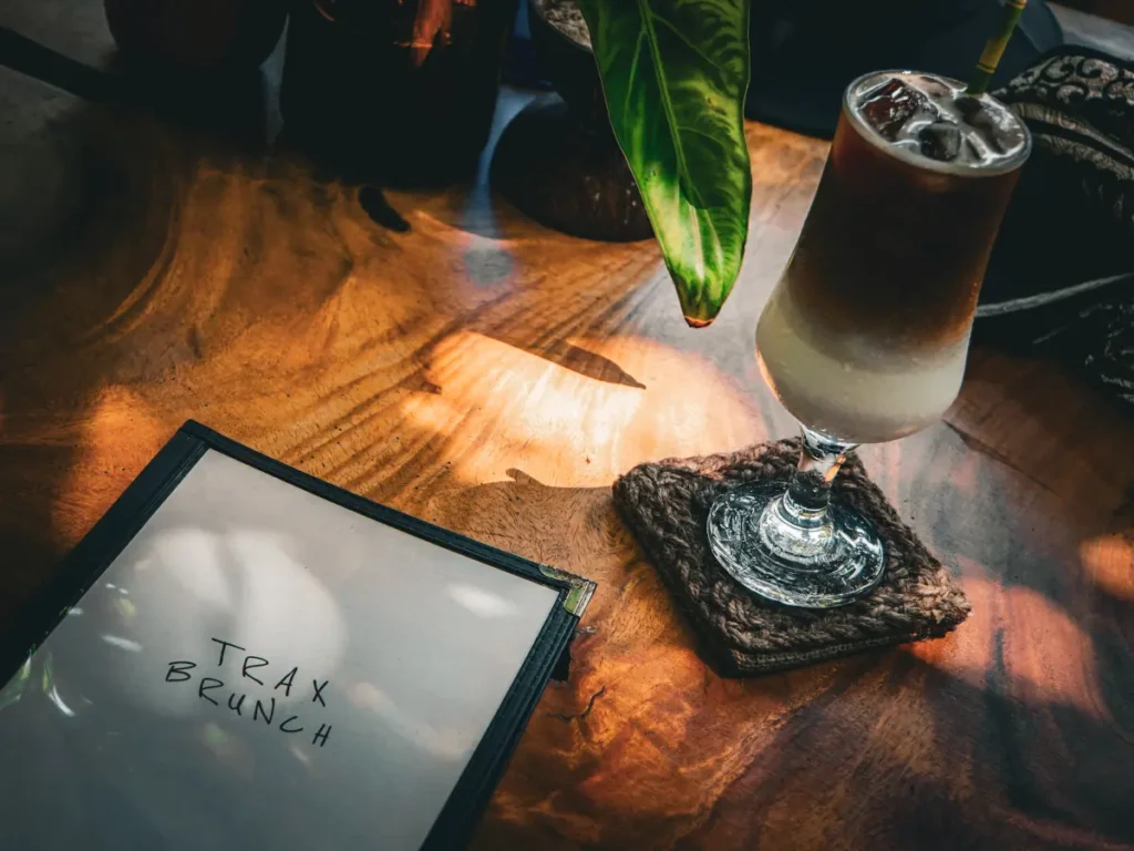 An iced coffee next to a menu at Trax bunch in Ahangama
