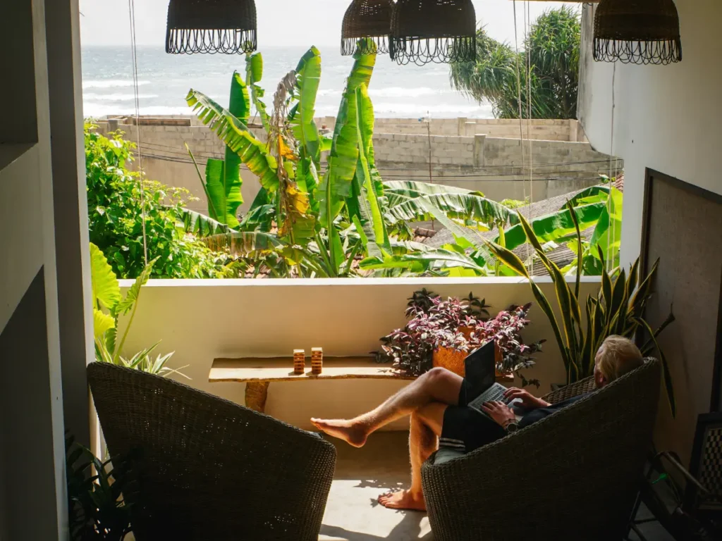A man works on his laptop whilst looking out to the ocean in Ahangama