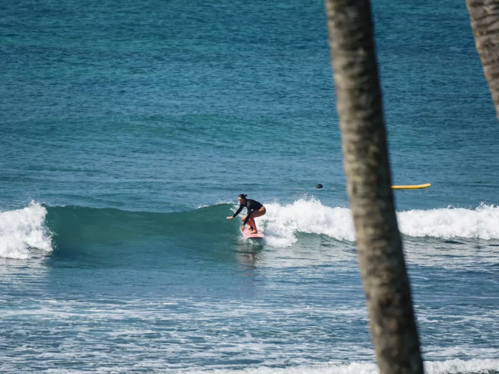 A beginner surfing a wave at Marshmallow surf spot, Ahangama