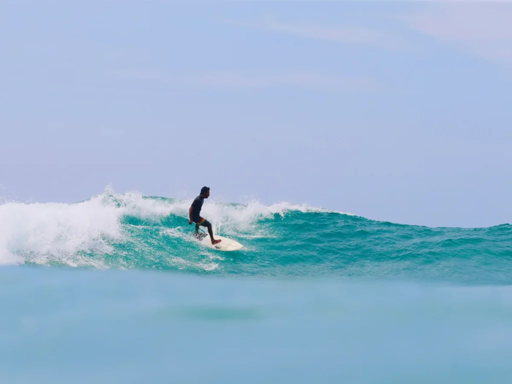 A surfer riding a wave at The Rock Kabalana