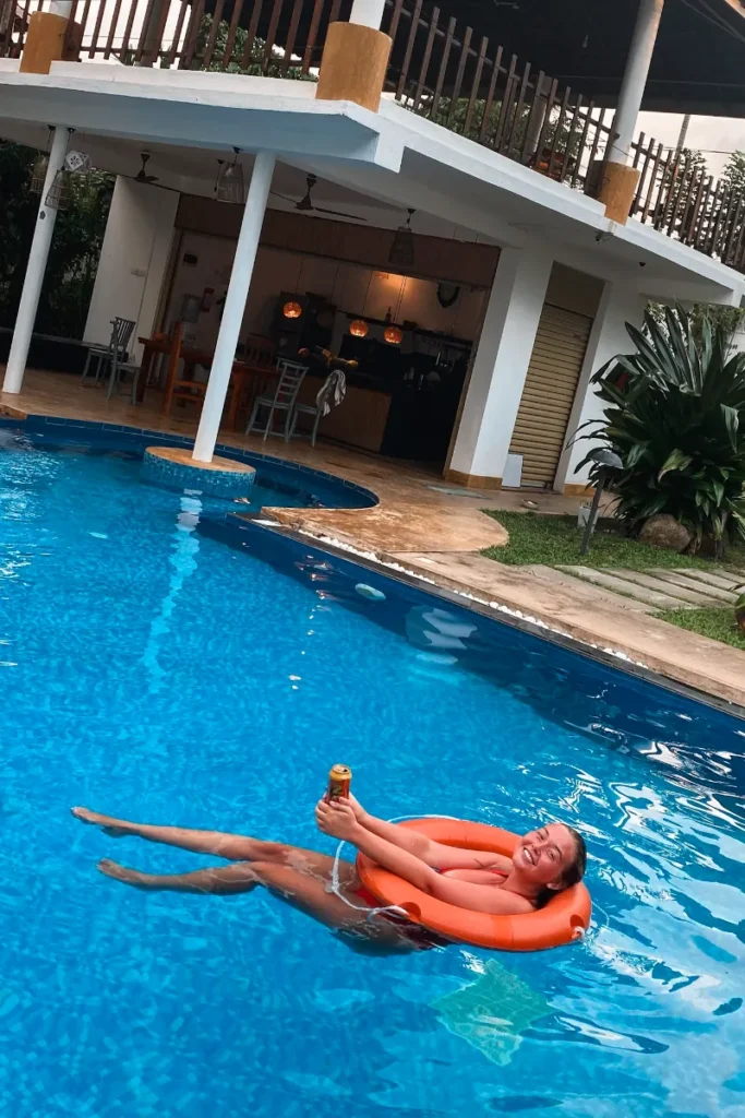 A girl drinking a beer in Venus Villa pool