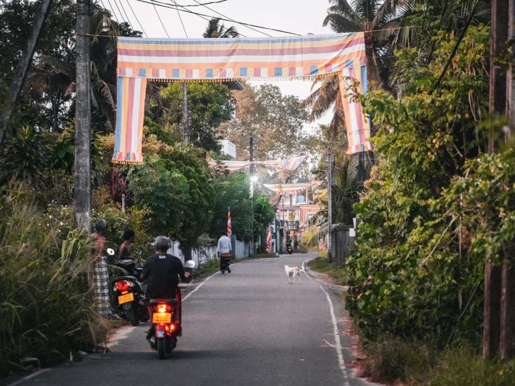 A local man drives a motorbike down a street Madiha