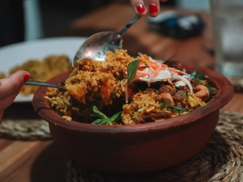 Two people share a Pot Biriyani takeaway in Madiha