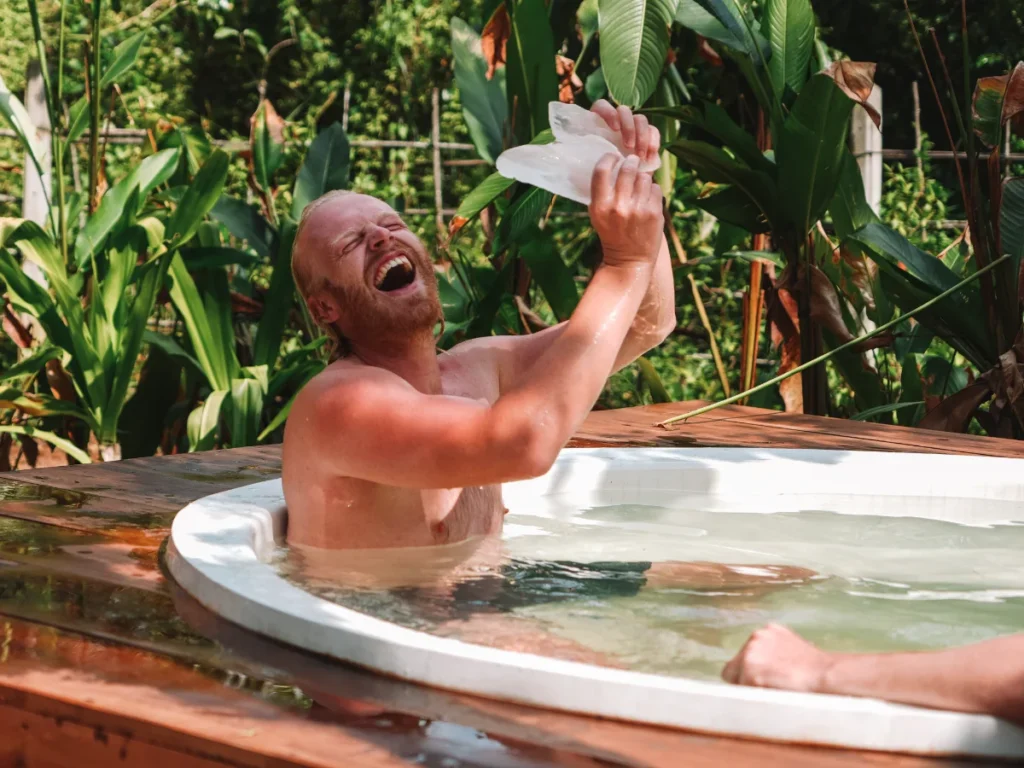 A man holding a giant piece of ice at the Ice Baths in Ahangama