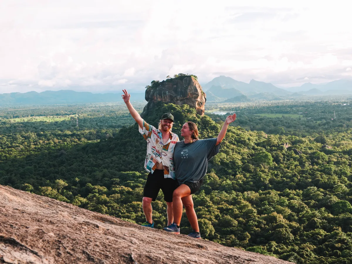A couple posing at the top of Pidurangala Rock with Sigiriya in the background
