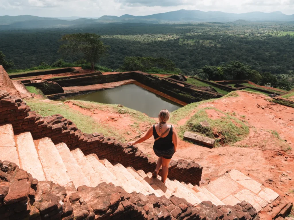 A girl looking at the landscape and pools at the top of Sigiriya