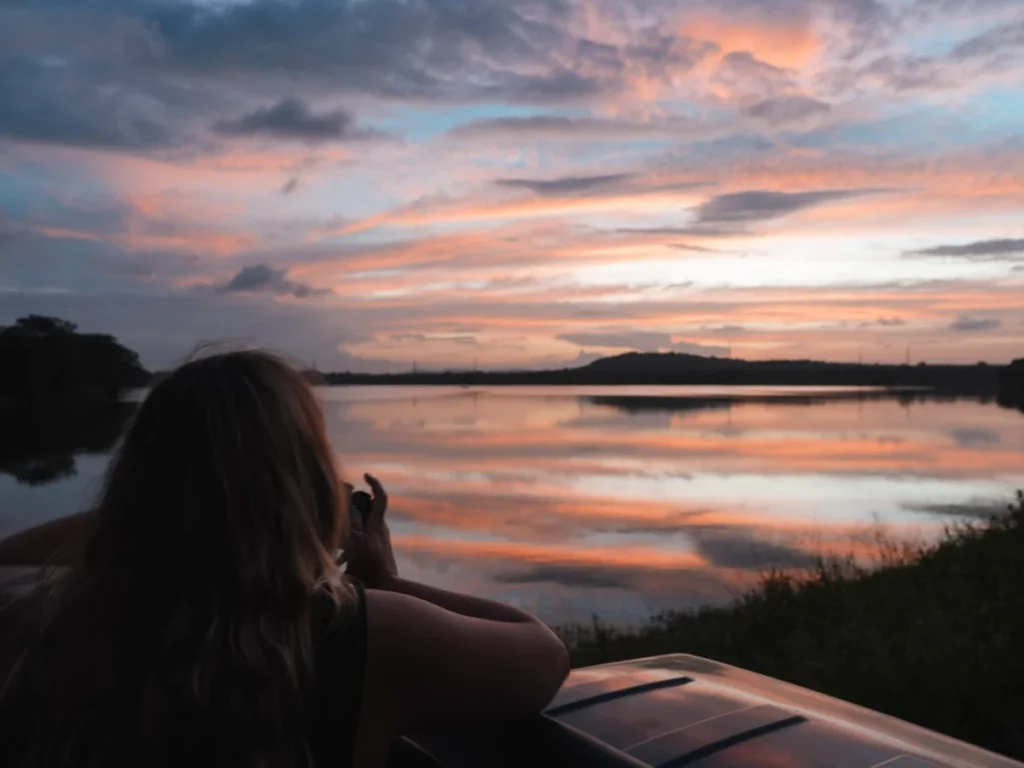 A girl looking for wildlife at sunset at Minneriya National Park