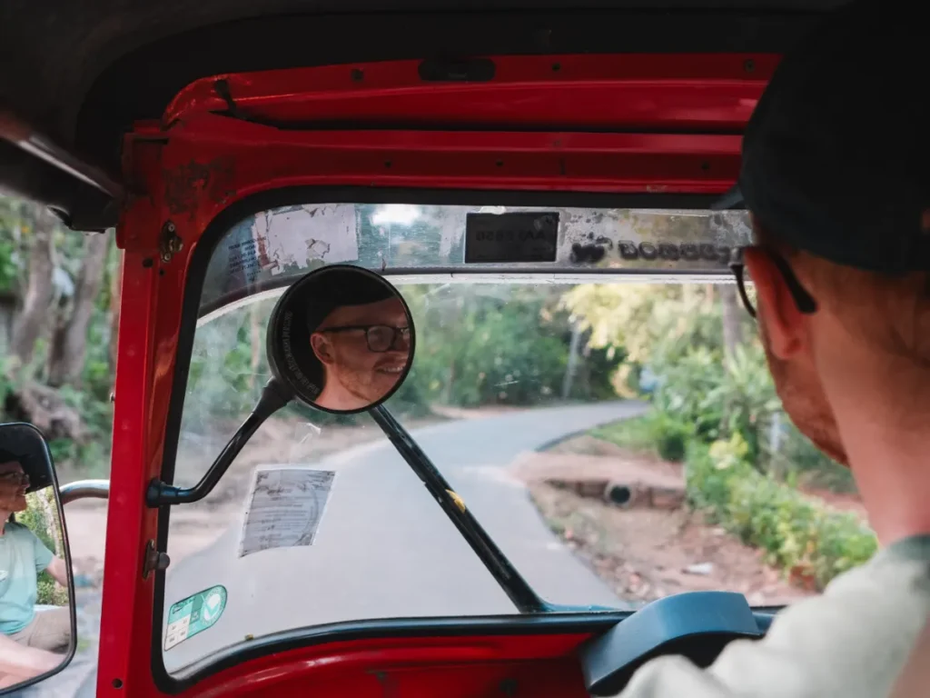A man learns to drive a Tuk Tuk, one of the top things to do in Sigiriya