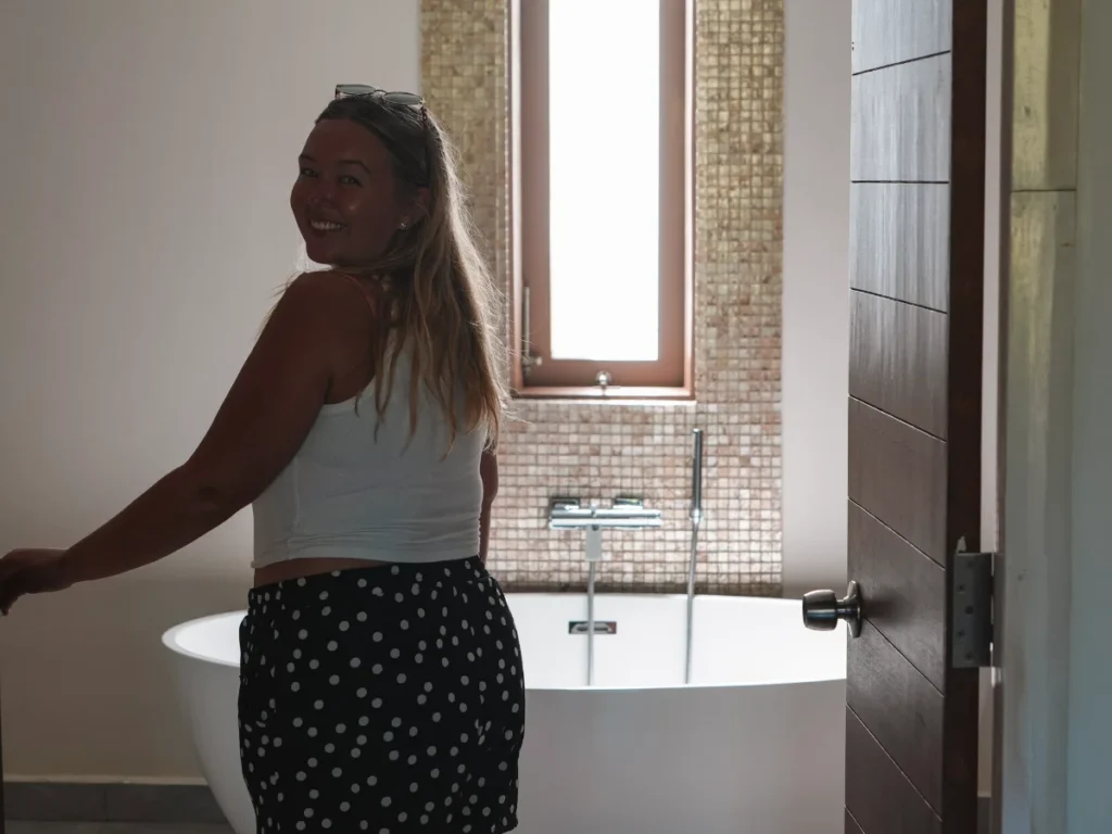 A girl smiles near the bathtub at Aprota Villa in Arugam Bay