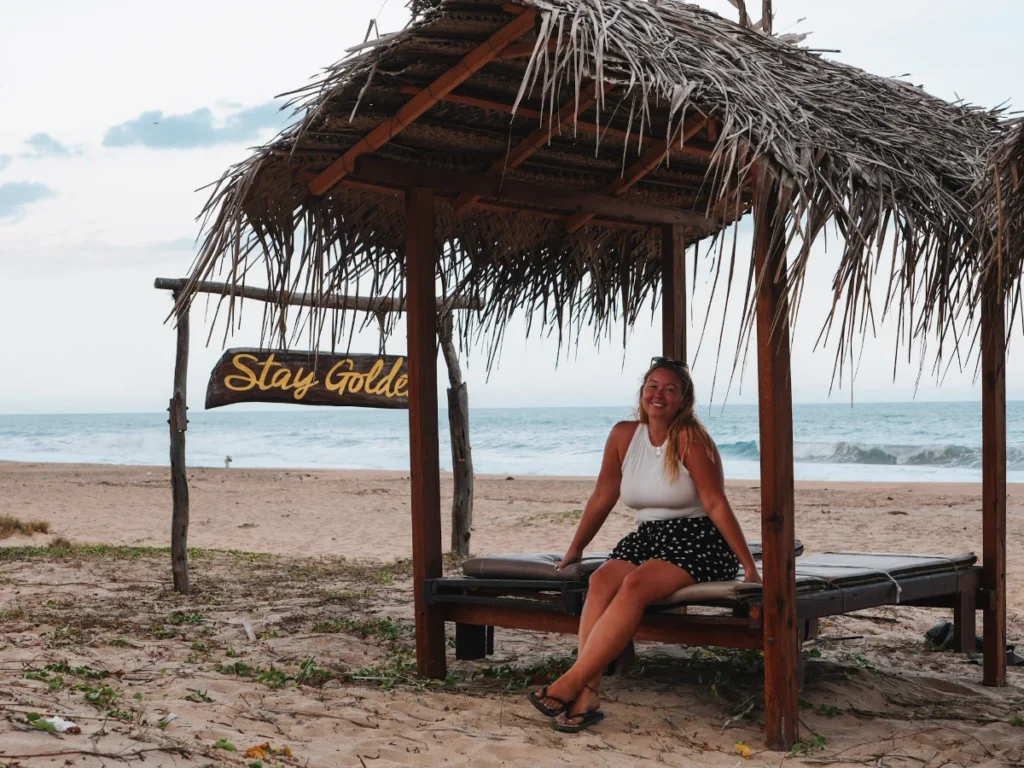 A girl sits on the beach beds at Stay Golden, one of the best hotels in Arugam Bay