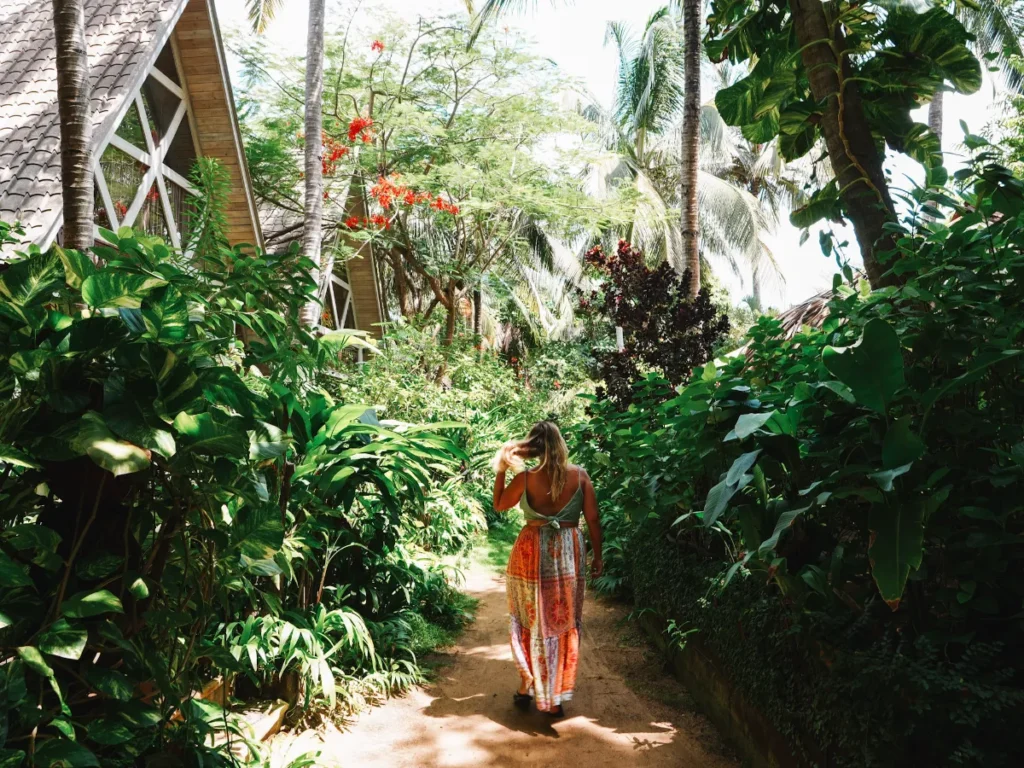 A girl walks down a jungle pathway at Surf N Stay, a top boutique hotel